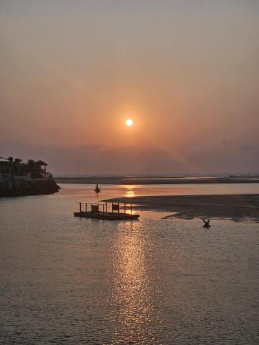 a sunset over a body of water with a dock at Malie Hotel in Águas Belas