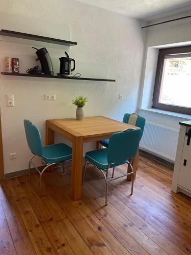a table and chairs in a room with a kitchen at Kleine, aber feine Unterkunft mit direktem Waldzugang in Hauenstein