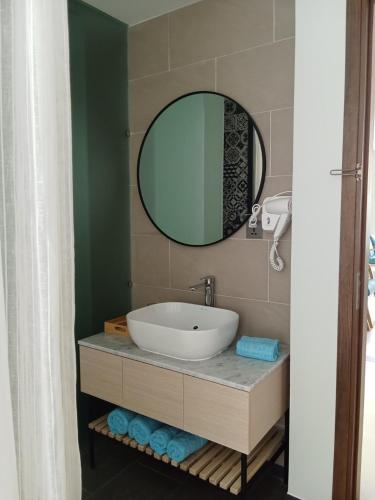 a bathroom with a sink and a mirror at The Vista Beach Resort Phan Thiết in Phan Thiet
