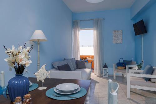 a blue living room with a couch and a table at Ariadne Apartments in Kato Gouves
