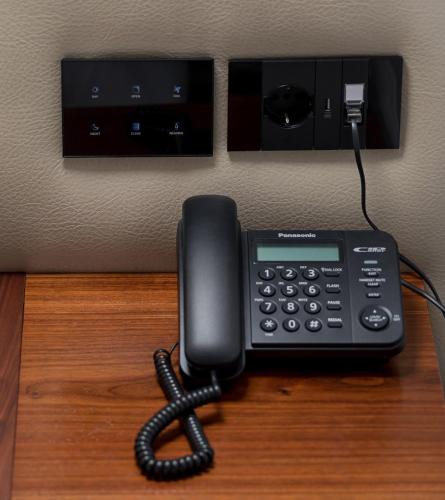 a phone sitting on top of a desk at Mert Boutique Hotel in Korçë