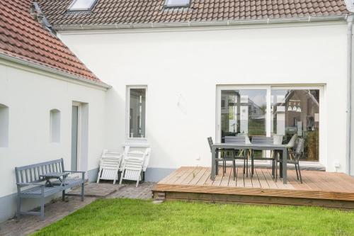 a patio with a table and chairs on a deck at Friesenhus - Jever in Jever