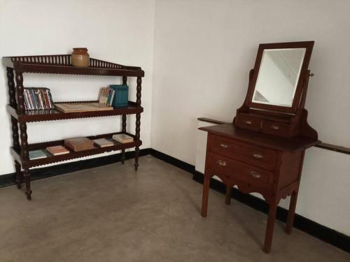 Cette chambre comprend une commode et un miroir sur une table. dans l'établissement The Birds Rest, à Sri Jayewardenepura Kotte