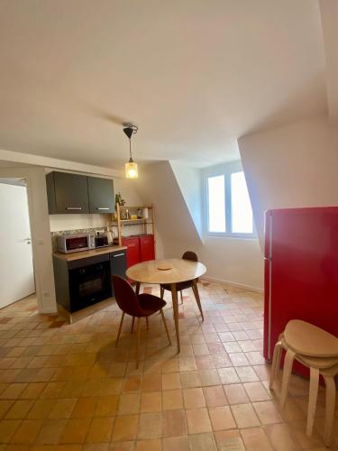 une cuisine avec une table et des chaises dans une pièce dans l'établissement Logement entier - Vieux Tours - Centre - 3 chambres, à Tours