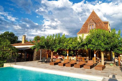 un complexe avec une piscine bordée de chaises et d'arbres dans l'établissement Les Constancies luxury Villa 24-34 pers, à Valades