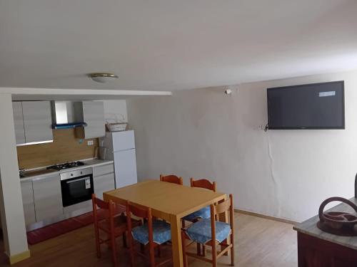 a kitchen with a table and chairs and a television at Nonno Ludovico in Roccasicura