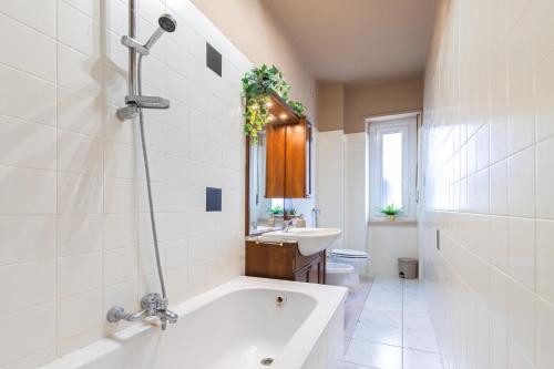 a white bathroom with a tub and a sink at URBAN House in Rivoli
