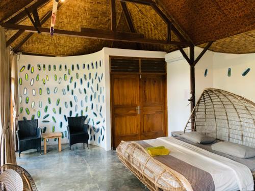 a bedroom with a bed and chairs in a room at Yoga Lover in Yogyakarta