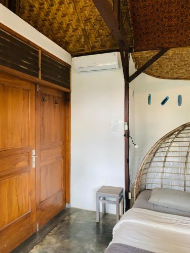 a bedroom with a bed and a wooden door at Yoga Lover in Yogyakarta