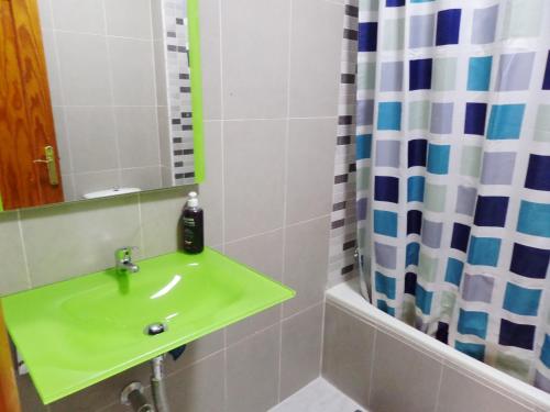 y baño con lavabo verde y ducha. en apartamentos Centro PICASSO, en Málaga