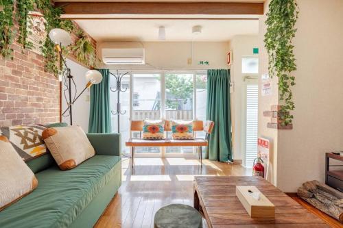a living room with a green couch and a table at 横浜中央2丁目 in Yokohama