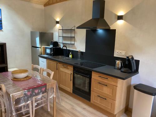 une cuisine avec un comptoir noir et une table dans l'établissement Chalet MELBA Le Clos des Ours, à Matemale