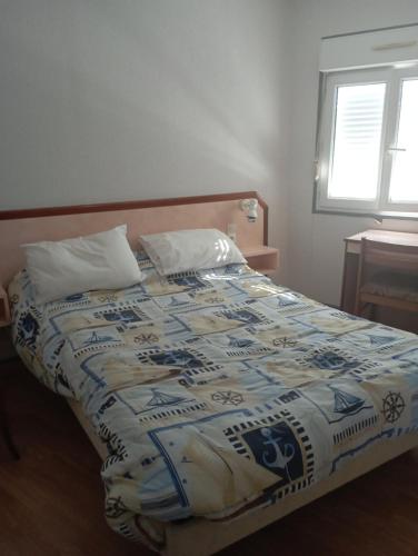 - un lit avec une couette bleue et blanche dans l'établissement Saint Pair sur Mer 50 m de la plage, à Saint-Pair-sur-Mer