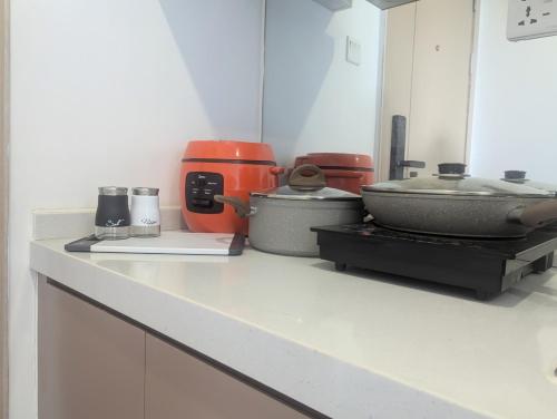 a kitchen counter with various appliances on it at Claudio Homestay - 11th Floor - City Views - 55 UHD TV in Phnom Penh