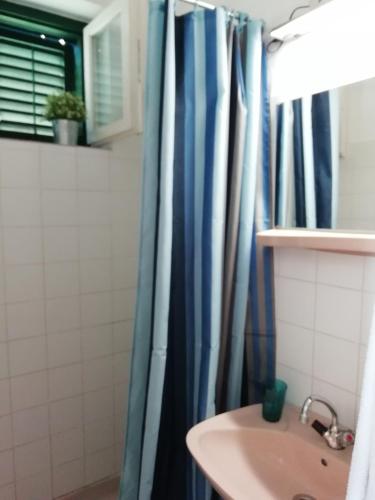 a bathroom with a shower curtain and a sink at Villa Balcsi in Balatonmáriafürdő