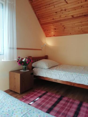 a bedroom with two beds and a vase of flowers on a table at Villa Balcsi in Balatonmáriafürdő