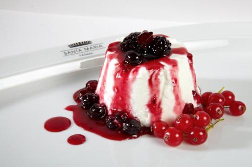 a piece of cake with berries on a plate at Hotel Santa Maria in Fátima