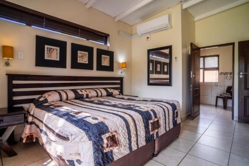 a bedroom with a bed and a bathroom at ATKV Buffelspoort in Rustenburg