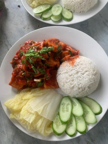 two plates of food with rice and vegetables on a table at Peaceful refuge homestay in Ninh Binh