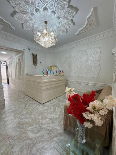 a living room with a chandelier and flowers in a room at Boutique Boulevard Bukhara in Bukhara