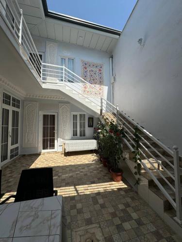 a patio with a staircase and a white house at Boutique Boulevard Bukhara in Bukhara