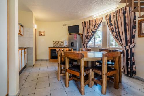 a kitchen and dining room with a wooden table and chairs at ATKV Buffelspoort in Rustenburg