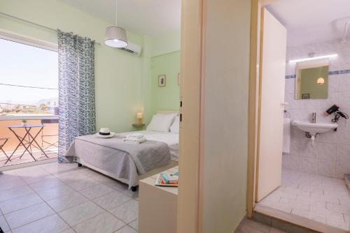 a bedroom with a bed and a bathroom with a sink at Ariadne Apartments in Kato Gouves