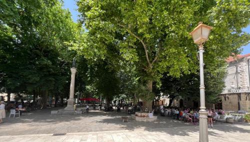 a street light in a park with a crowd of people at Relax Apartments Trebinje in Trebinje