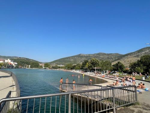 a group of people in the water at a beach at Relax Apartments Trebinje in Trebinje