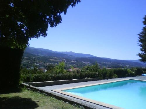 a large swimming pool with a view of a city at Quinta de Bóco in Arouca