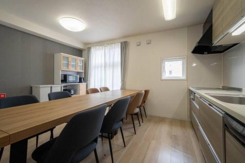 a kitchen with a long wooden table and chairs at Flex cella satozuka in Ōmagari