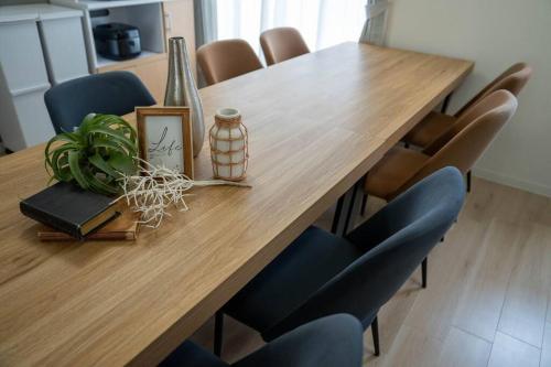 a wooden table with chairs and a plant on it at Flex cella satozuka in Ōmagari