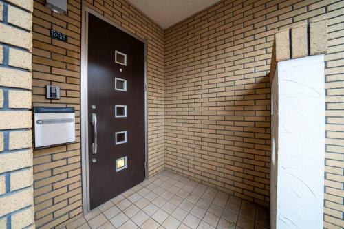 a brick room with a door and a brick wall at Flex cella satozuka in Ōmagari