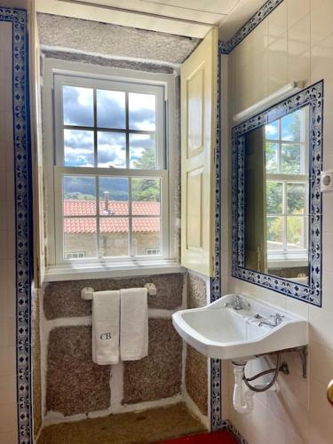 a bathroom with a sink and a window and a mirror at Quinta de Bóco in Arouca