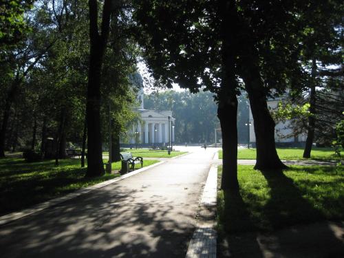 a path in a park with a bench and trees at Ultra Central Park Apartments in Chişinău