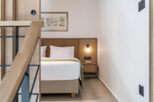 a hotel room with a bed and a staircase at Inea Sole Boutique Hotel in Kato Daratso