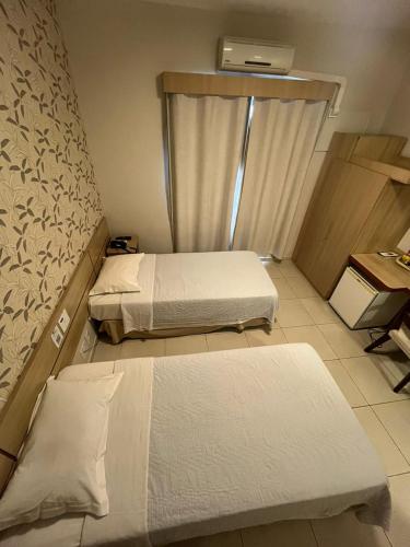 a room with two beds and a desk at Hotel Serra de Jundiaí in Jundiaí