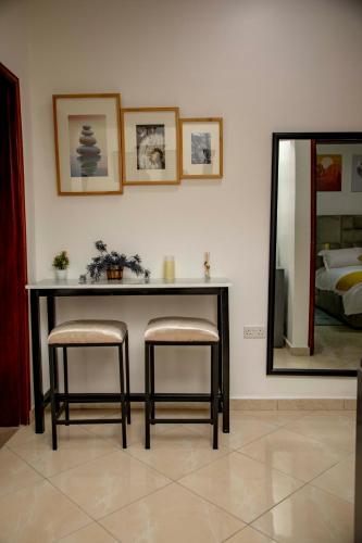 a table with two stools in a room with a mirror at Lovana Apartments and Hotel, Gulu City in Gulu