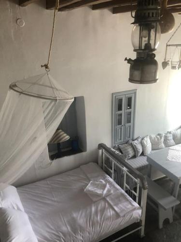 a bedroom with a bed and a table and a mirror at TaVLaDo Cycladic house in Serifos Chora