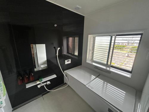 a bathroom with a sink and a window at Traditional Japanese Style Vacation Rentals ToBay 古民家民泊藤兵衛 in Eiheiji