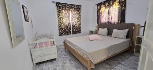 a bedroom with a bed and a dresser and curtains at Ain draham sejour 2, appartement trois pièces privé, seulement familles in Bābūsh