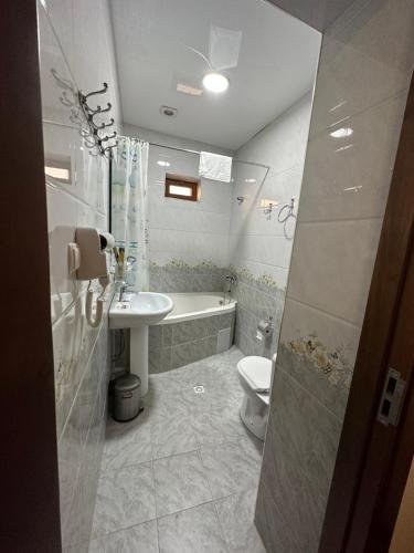 une salle de bains avec lavabo, baignoire et toilettes dans l'établissement Hotel POYI KALON terrace حلال, à Boukhara