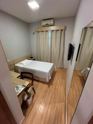 a small room with a bed and a table at Hotel Serra de Jundiaí in Jundiaí