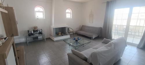 a living room with a couch and a fireplace at CAMARES HOUSE in Áyioi Apóstoloi