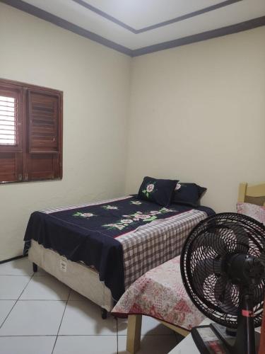 a bedroom with a bed and a fan at House beach in Camocim