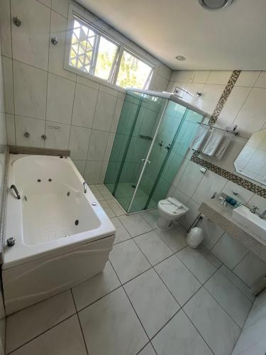 a bathroom with a tub and a toilet and a shower at Hotel Serra de Jundiaí in Jundiaí