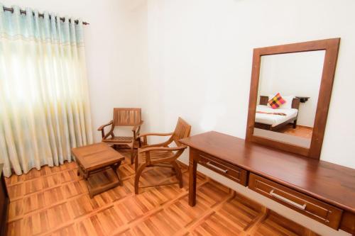 a room with a dresser and a mirror and a chair at Sholay Villa in Galle