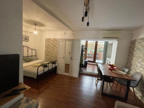 a living room with a dining table and a bedroom at Apartma Ella in Koper