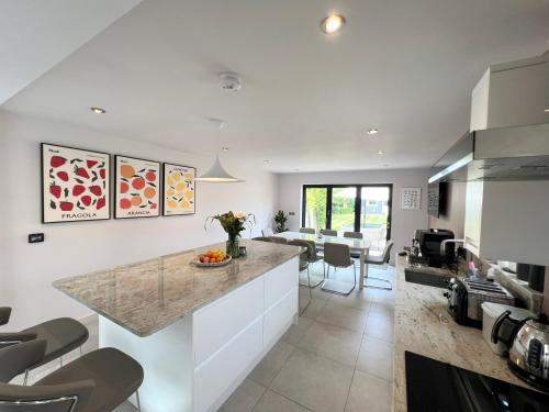 a kitchen with a counter and a living room at Luxury Family Home in Central Windsor with Large Garden, Games Room, Office, Parking & Pet-Friendly in Windsor