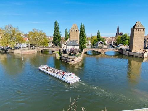 a boat in a river with people on it at Beau studio proche Strasbourg in Illkirch-Graffenstaden